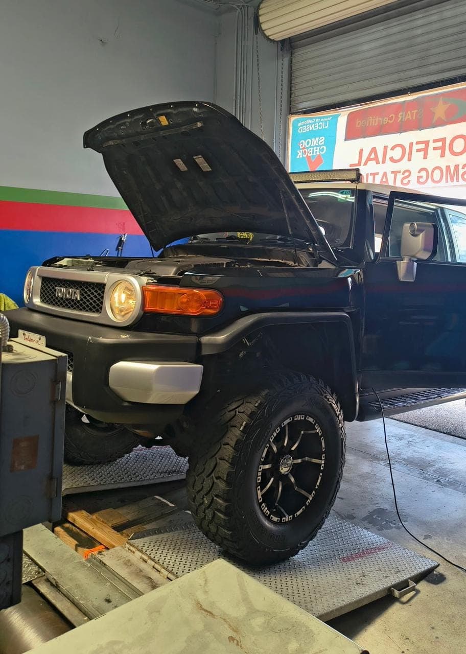 Lifted black Toyota FJ Cruiser with the hood open in the test bay