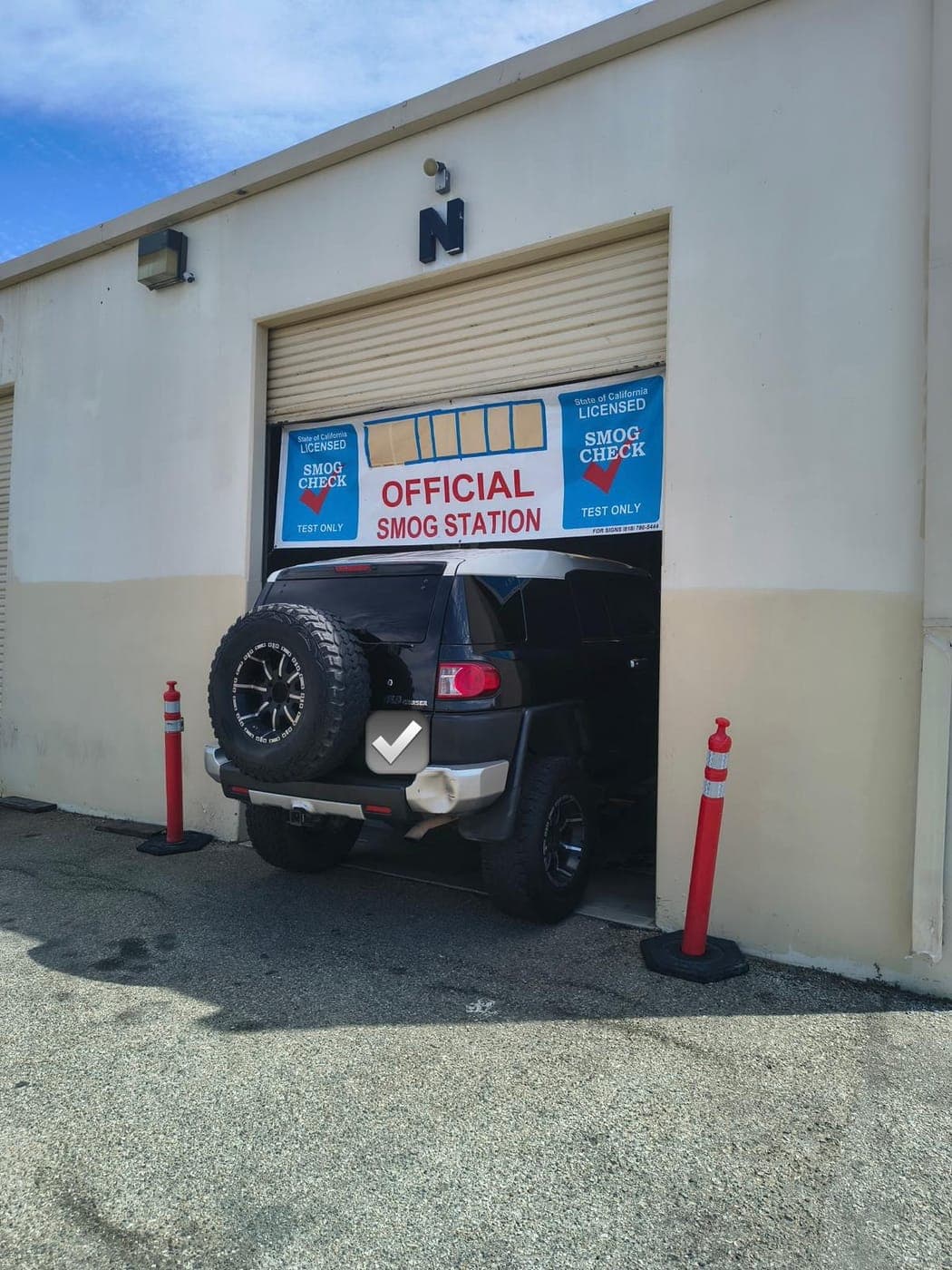 Black FJ Cruiser with a spare tire entering the Official Smog Station bay