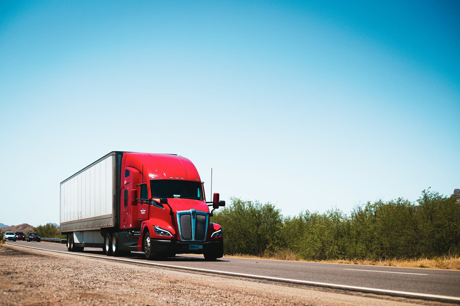 Red semi truck hauling a trailer on a desert highway